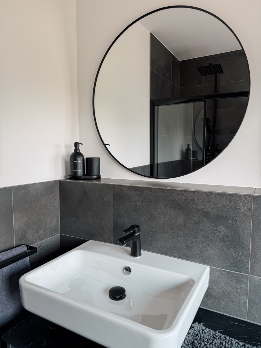 Badezimmer mit Waschbecken und Spiegel